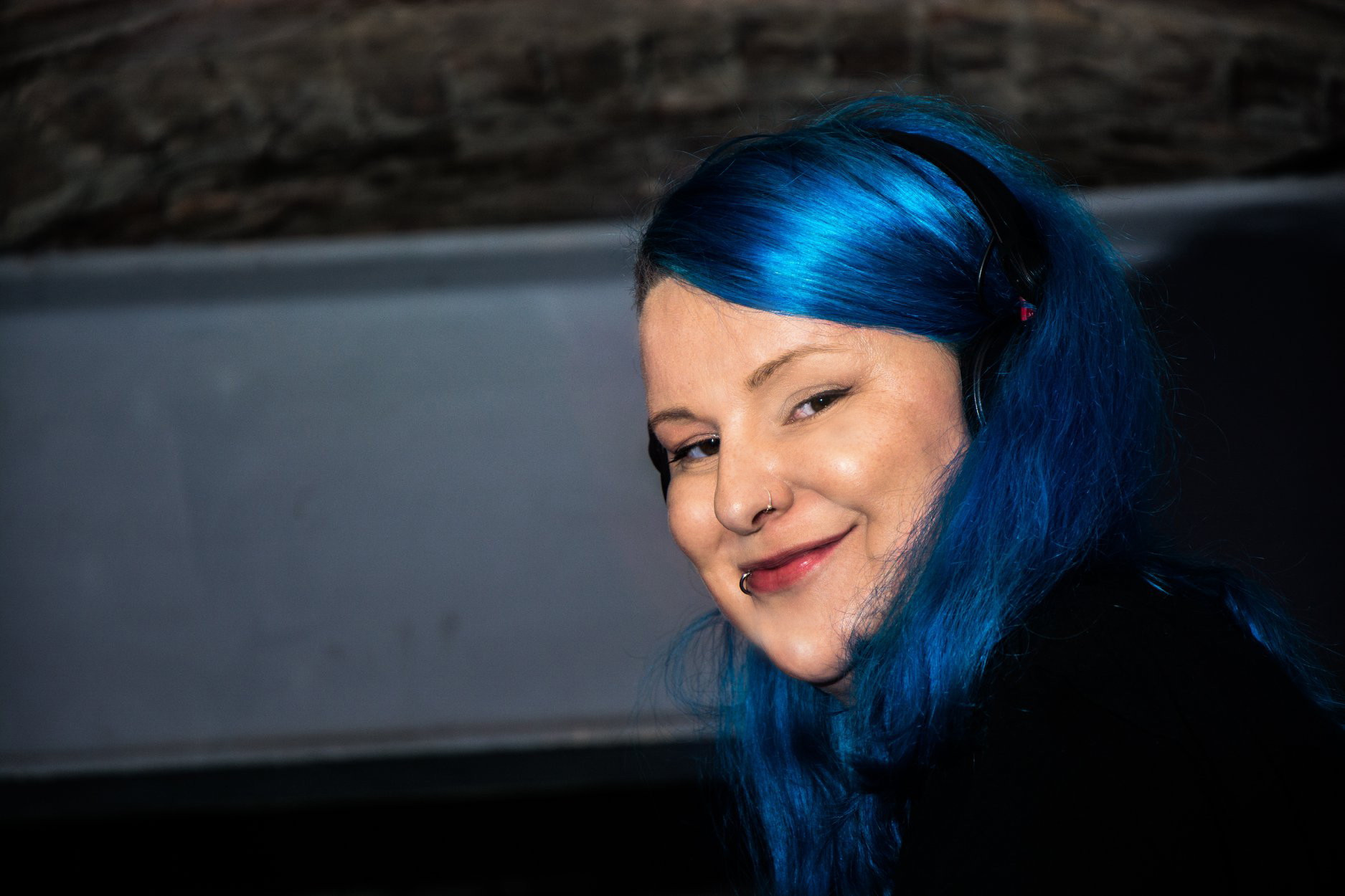 DJ Sati Djane Sati lächelt in die Kamera. Sie hat blaue Haare.