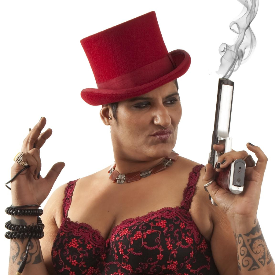 Ma Faiza Die Djane Ma Faiza ist frontal zu sehen. Sie trägt ein rotes Korsett und einen roten Zylinder. In der linken Hand hält sie eine rauchende Pistole.