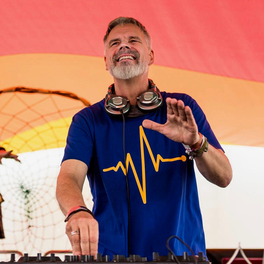 Vargo DJ Vargo an den Turntables. Er trägt Kopfhörer um den Hals und schaut Richtung Publikum.