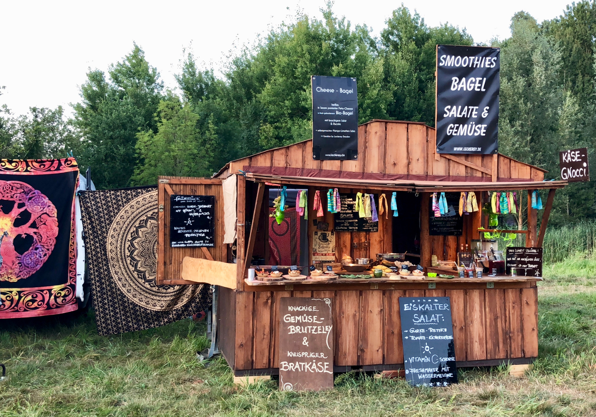 Leckerey Der Stand der Leckerey auf dem New Healing Festival. Der Stand ist aus Holz und verfügt über 5 Kreidetafeln auf denen die Angebote stehen.