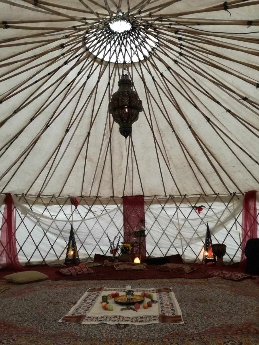 Temple of Sacred Sensuality Das Bild zeigt den Innenraum eines großen Zeltes. Auf dem Boden liegt ein Teppich. In der Mitte hängt eine schwarze Lampe.