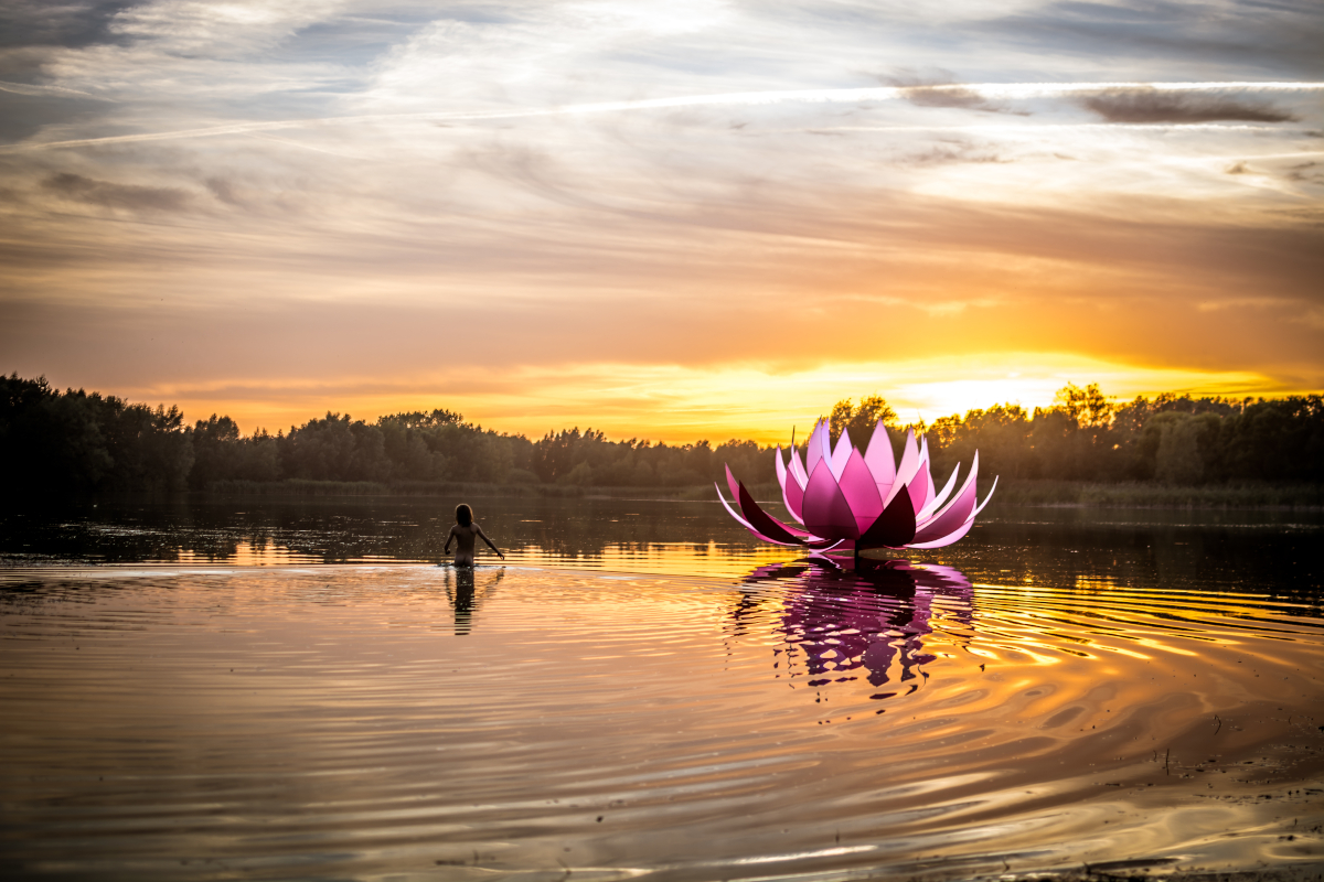 Badesee-preddoehl Sonnenuntergang am Badesee Preddöhl. Im See befindet sich ein Kind. Rechts davon ein Skulptur in Form einer Lotusblume.