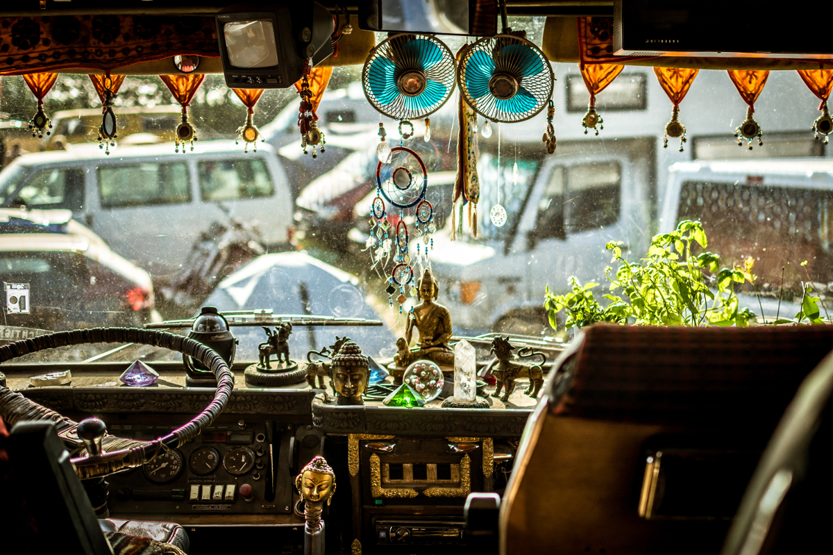 Camping-autos Man sieht den Blick durch die Frontscheibe eines Wohnmobils. Der Innenraum ist stark geschmückt. Durch die Frontscheibe sieht man eine Gruppe von Wohnmobilen